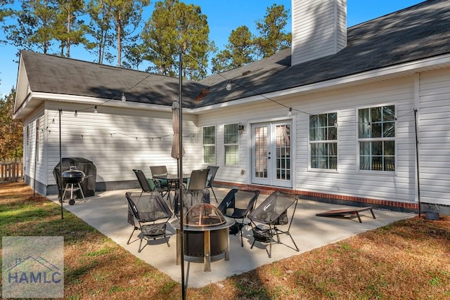 view of patio featuring french doors, an outdoor fire pit, and a grill