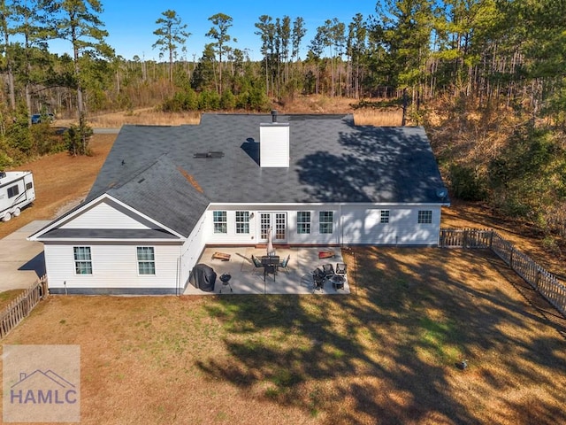 back of property featuring a patio area, a fenced backyard, a chimney, and a yard