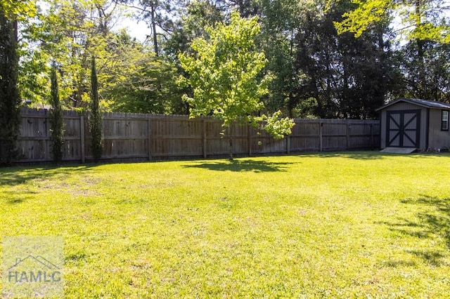 435 Arlington Dr, Hinesville, GA 31313 - view of yard featuring a shed, a fenced backyard, and an outbuilding
