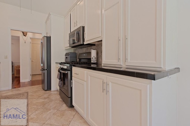 435 Arlington Dr, Hinesville, GA 31313 - kitchen featuring tasteful backsplash, light tile patterned floors, dark countertops, white cabinets, and stainless steel appliances