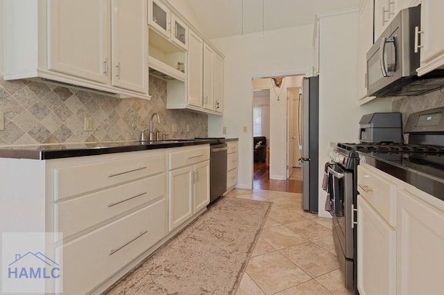 435 Arlington Dr, Hinesville, GA 31313 - kitchen featuring light tile patterned floors, backsplash, dark countertops, stainless steel appliances, and a sink
