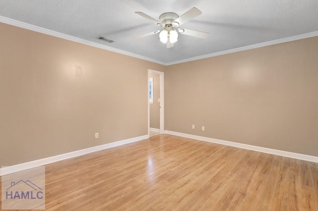 spare room featuring a ceiling fan, light wood-type flooring, visible vents, and baseboards