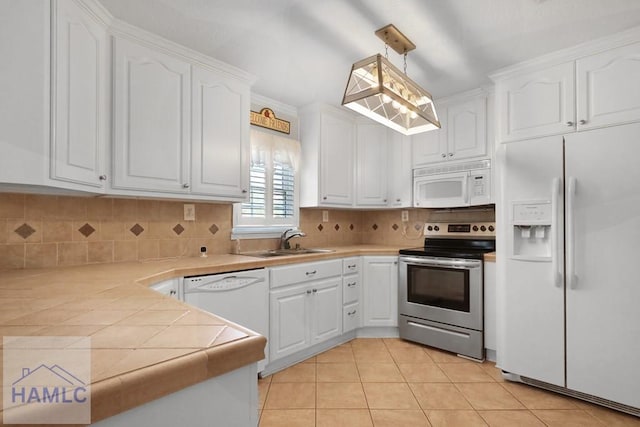 kitchen featuring white appliances, decorative backsplash, white cabinets, and a sink