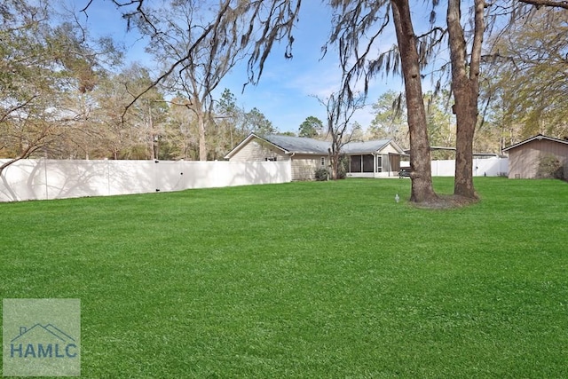 view of yard featuring fence private yard and a sunroom