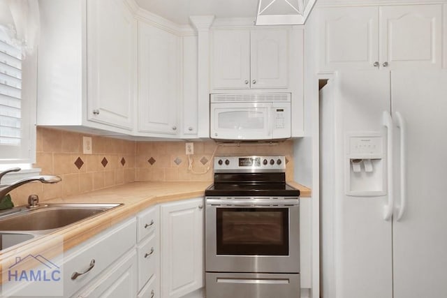 kitchen featuring white appliances, tasteful backsplash, and white cabinets