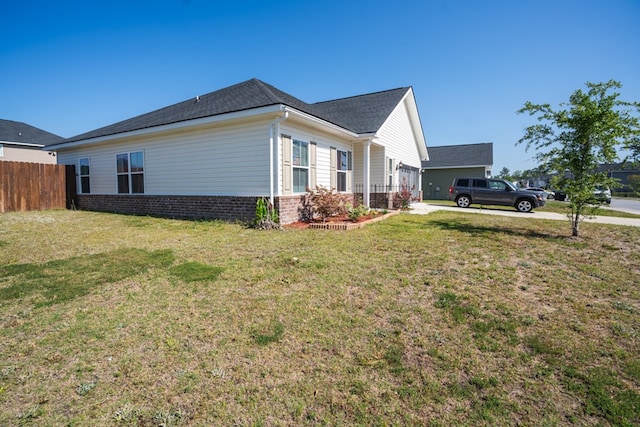 view of side of home featuring a garage and a lawn