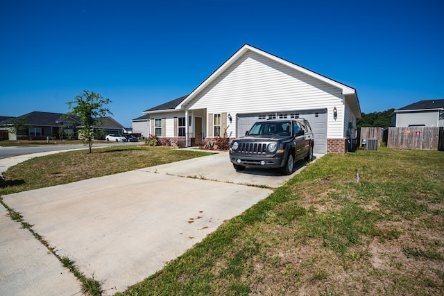 view of front of property featuring cooling unit, a garage, and a front yard