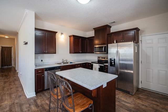 361 Thorp Cir, Hinesville, GA 31313 - kitchen with appliances with stainless steel finishes, sink, a kitchen bar, a center island, and dark wood-type flooring