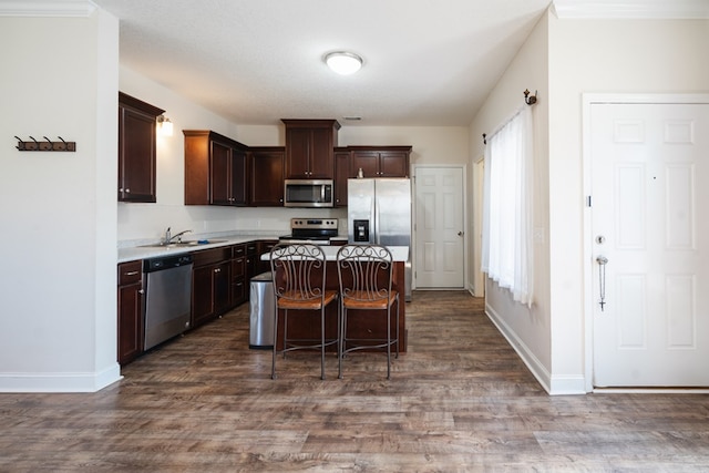 361 Thorp Cir, Hinesville, GA 31313 - kitchen featuring dark brown cabinetry, a kitchen bar, a center island, appliances with stainless steel finishes, and dark hardwood / wood-style flooring