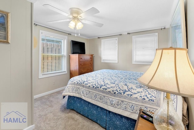 carpeted bedroom featuring ceiling fan and crown molding