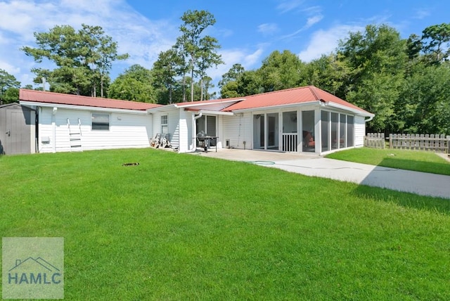 back of property with a lawn and a sunroom