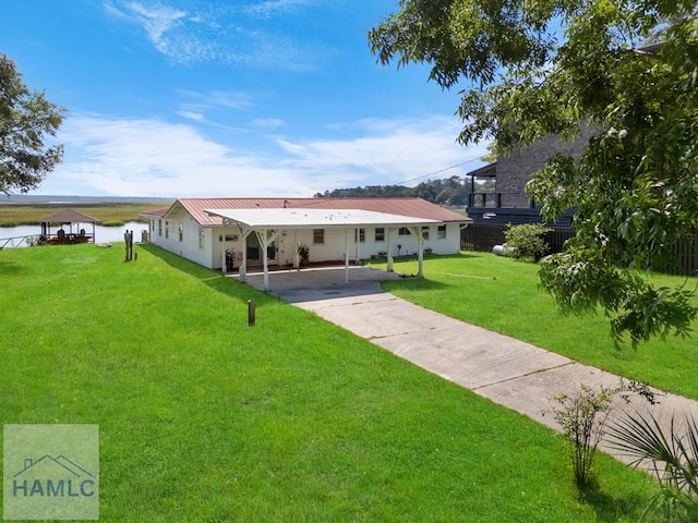 exterior space featuring a front lawn, a water view, and a carport