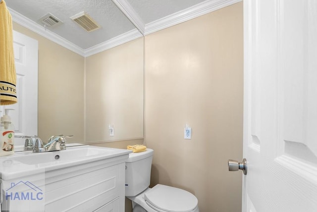 bathroom with a textured ceiling, vanity, toilet, and crown molding