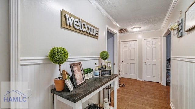 705 S 11th St, Jesup, GA 31545 - hallway with wood finished floors, a textured ceiling, wainscoting, and ornamental molding