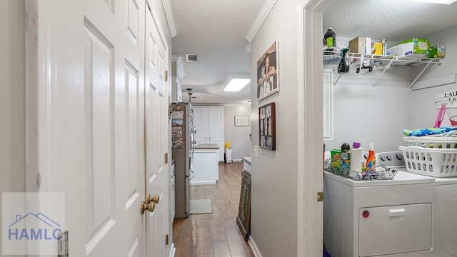 705 S 11th St, Jesup, GA 31545 - washroom featuring washing machine and clothes dryer, light wood finished floors, and a textured ceiling