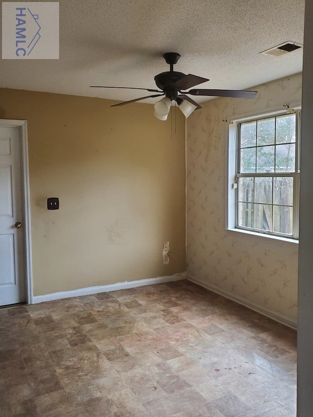 unfurnished room featuring a textured ceiling and ceiling fan