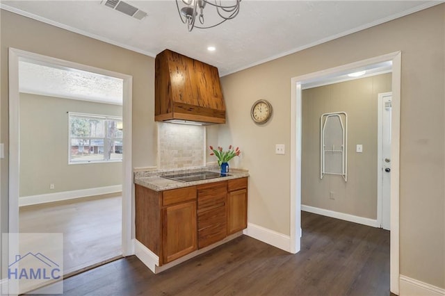 105N Bay St, Jesup, GA 31545 - kitchen featuring custom exhaust hood, black electric cooktop, dark wood finished floors, brown cabinets, and light stone countertops