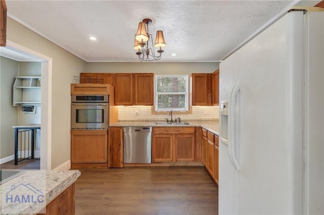105N Bay St, Jesup, GA 31545 - kitchen with appliances with stainless steel finishes, a sink, backsplash, light countertops, and wood finished floors