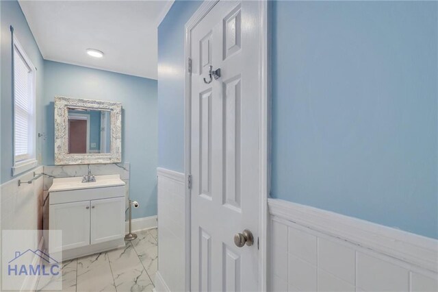 105N Bay St, Jesup, GA 31545 - bathroom featuring a wainscoted wall, marble look tiles, and vanity
