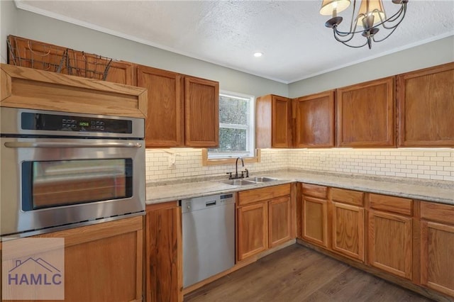 105N Bay St, Jesup, GA 31545 - kitchen featuring appliances with stainless steel finishes, a sink, a chandelier, dark wood-style floors, and decorative backsplash