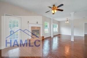 unfurnished living room with a tile fireplace and ceiling fan