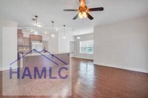 interior space with ceiling fan, hanging light fixtures, and dark hardwood / wood-style floors