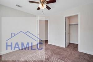 unfurnished bedroom with ceiling fan, a closet, and dark carpet