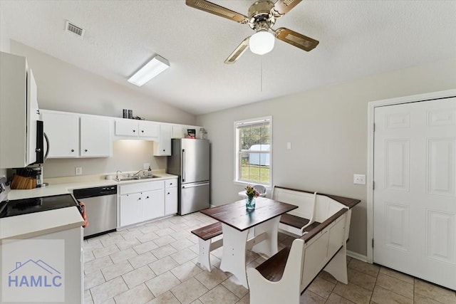 1105 Apache Aly, Hinesville, GA 31313 - kitchen with appliances with stainless steel finishes, vaulted ceiling, a ceiling fan, light countertops, and light tile patterned floors