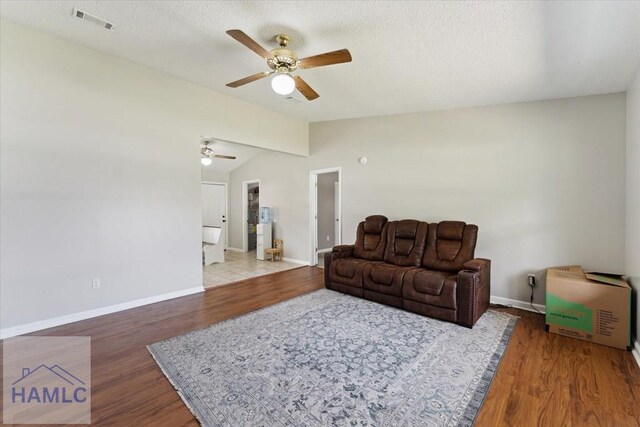1105 Apache Aly, Hinesville, GA 31313 - living area with ceiling fan, wood finished floors, vaulted ceiling, and a textured ceiling