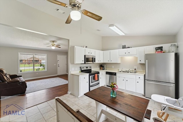 1105 Apache Aly, Hinesville, GA 31313 - kitchen with appliances with stainless steel finishes, open floor plan, ceiling fan, white cabinets, and high vaulted ceiling