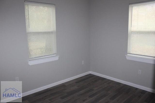 spare room featuring dark wood-type flooring and a healthy amount of sunlight