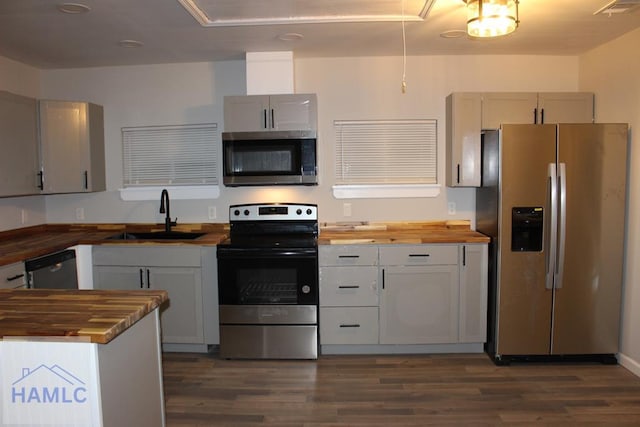 kitchen with dark hardwood / wood-style flooring, sink, wooden counters, and appliances with stainless steel finishes