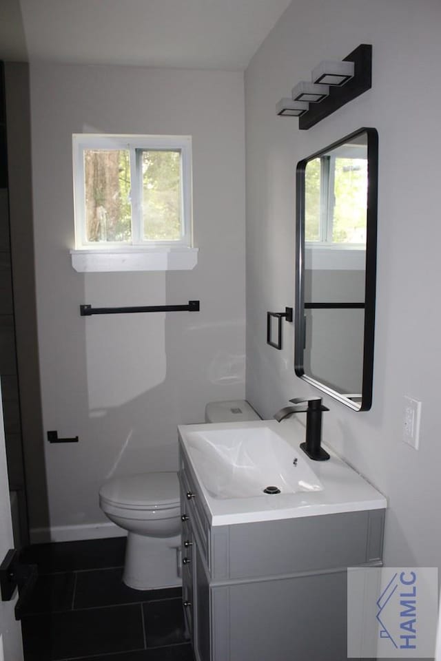 bathroom with tile patterned flooring, vanity, and toilet