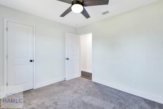 unfurnished bedroom with carpet flooring, baseboards, visible vents, and ceiling fan
