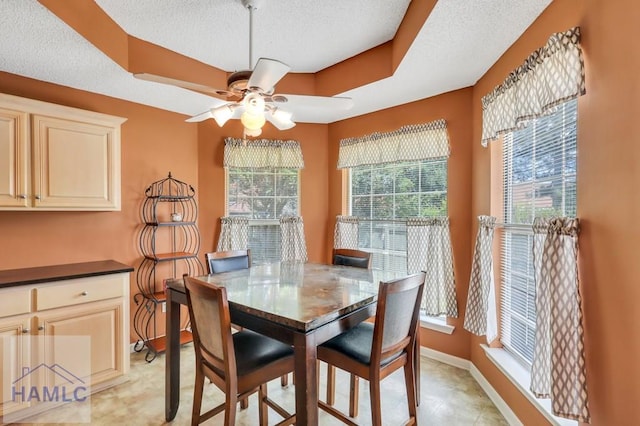 dining room with ceiling fan, a textured ceiling, and a wealth of natural light