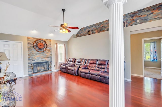 living room featuring lofted ceiling, ceiling fan, ornate columns, a fireplace, and wood-type flooring