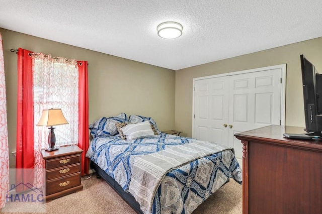 carpeted bedroom with a closet and a textured ceiling