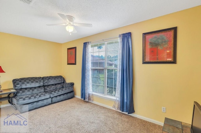 living room with a textured ceiling, carpet floors, and ceiling fan