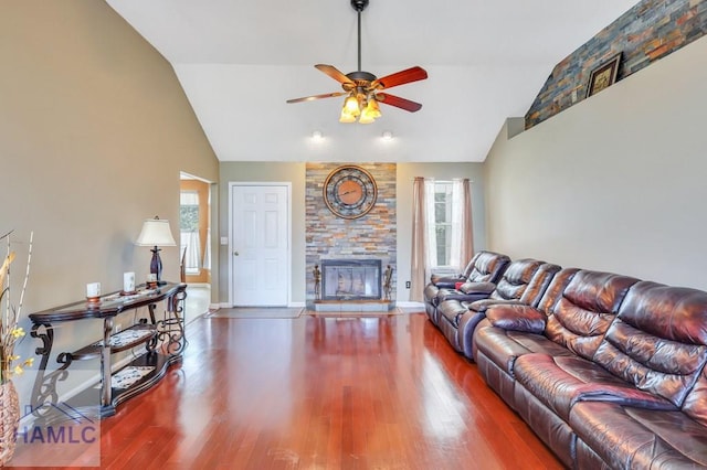 living room with a fireplace, a healthy amount of sunlight, dark wood-type flooring, and ceiling fan