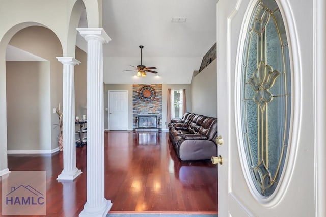 foyer featuring ornate columns, ceiling fan, a fireplace, and hardwood / wood-style flooring