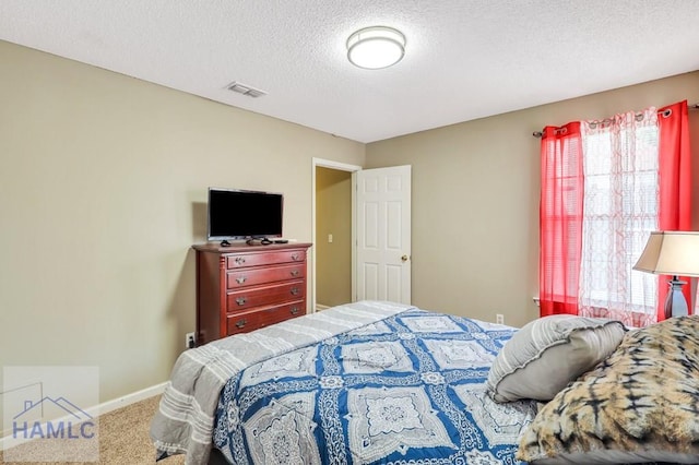 bedroom with carpet flooring and a textured ceiling