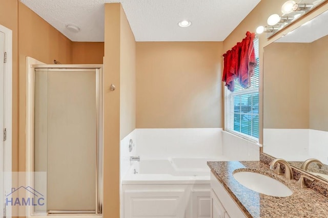 bathroom featuring vanity, separate shower and tub, and a textured ceiling