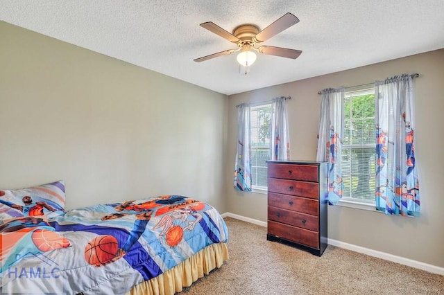 bedroom featuring a textured ceiling, ceiling fan, and light carpet