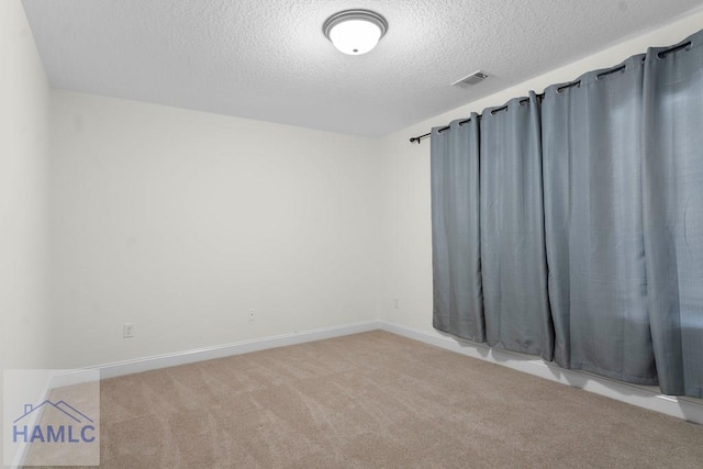 carpeted spare room with a textured ceiling