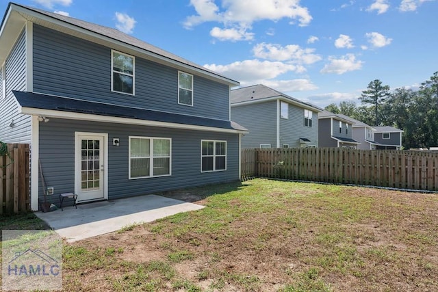 back of house with a yard and a patio