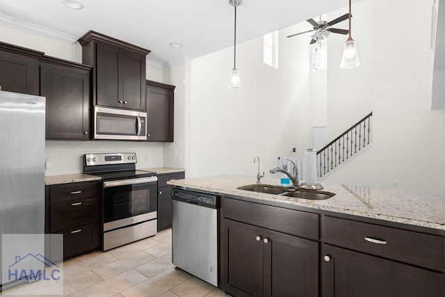 kitchen with dark brown cabinetry, ceiling fan, sink, stainless steel appliances, and ornamental molding