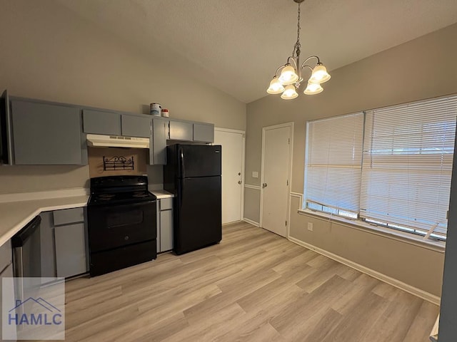 kitchen featuring under cabinet range hood, black appliances, gray cabinetry, and vaulted ceiling