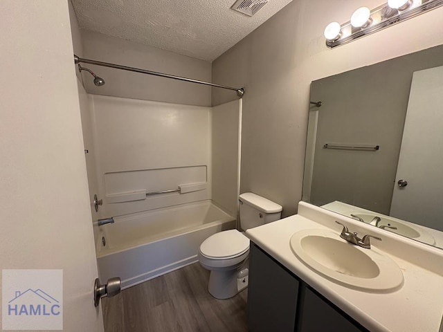 full bathroom with visible vents, toilet, a textured ceiling, wood finished floors, and vanity