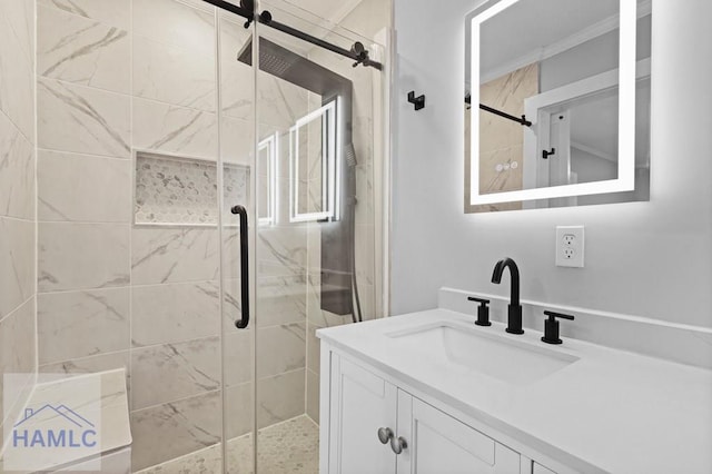 bathroom with a shower stall, vanity, and crown molding