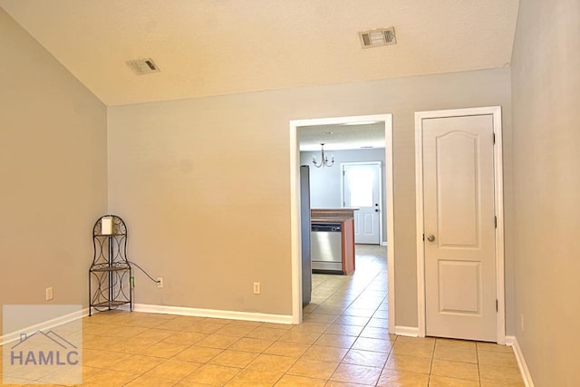 tiled empty room featuring a chandelier